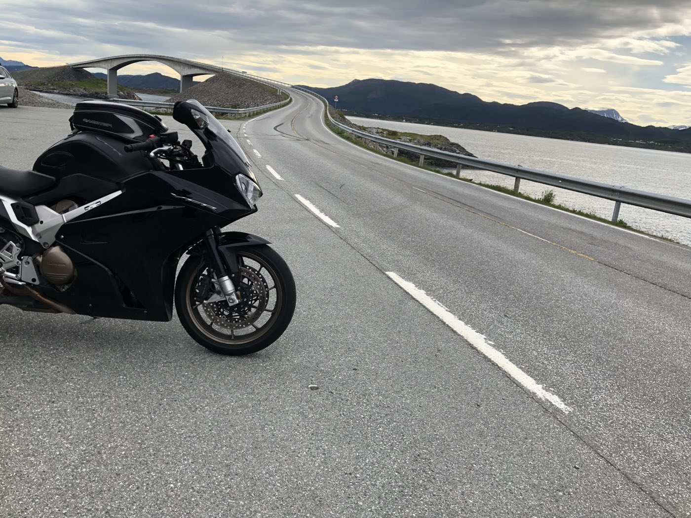 Motorsykkel parkert ved Atlanterhavsvegen med Storseisundbrua i bakgrunnen